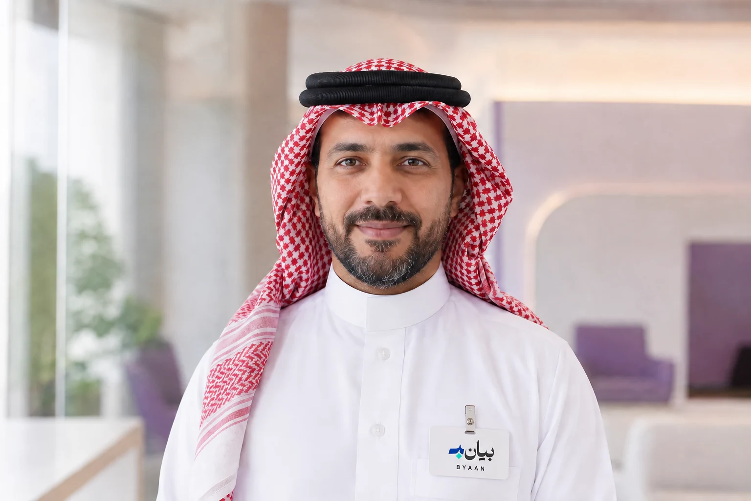 رجل سعودي بشماغ أحمر وبطاقة تعريف بيان على جيب الثوب